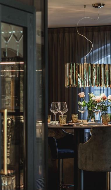 Hotelbereich mit beleuchteten Flaschenregalen und einem elegant gedecktem Tisch.