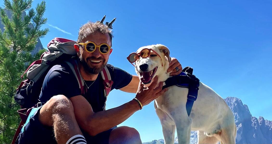 Mann mit einem Hund beim wandern