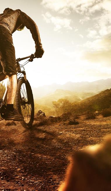 Mann beim Mountainbiken in steinigem Gelände.