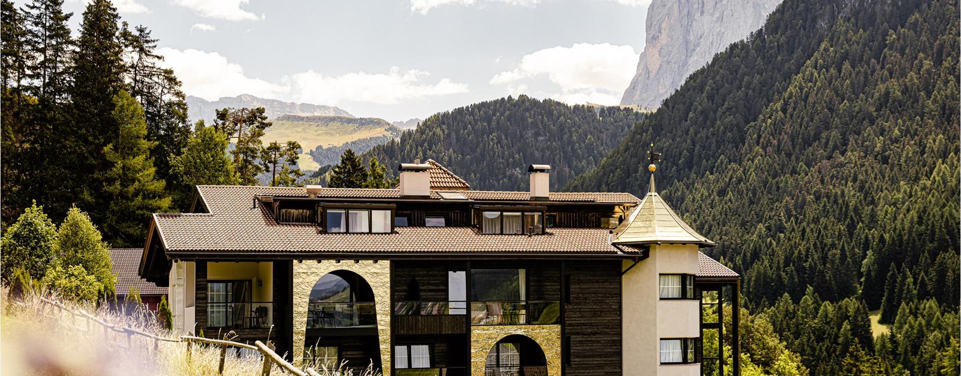 L'esterno dell'albergo con vista sul Sassolungo